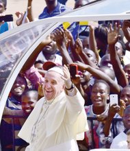 Pope Francis waves to cheering throngs of people who greeted and photographed his arrival from Kenya last Saturday at the Kololo airstrip in Kampala, Uganda. The pontiff spent two days in Uganda before continuing on to the Central African Republic.