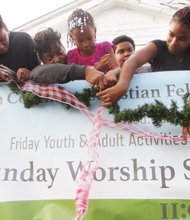 It’s that time of the year again as churches, synagogues, schools, businesses and others in the community spread holiday cheer and promote a giving spirit by putting up festive decorations, organizing community programs and donating their time and gifts to help others. In that spirit, Mary G. Gleaton, senior pastor at Faith Covenant Christian Fellowship Church, second from left, is joined by youths from the church in putting up decorations Nov. 27 outside the church at 1400 Spotsylvania St. in the East End.