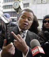 Pastor Stephen A. Parson Sr. of the Richmond Christian Center points to Donald Trump’s book, “Why We Want You to be Rich: Two Men, One Message,” co-authored with Robert Kiyosaki, as he talks to members of the media Monday in New York before the meeting of about 100 African-American ministers with the GOP candidate.