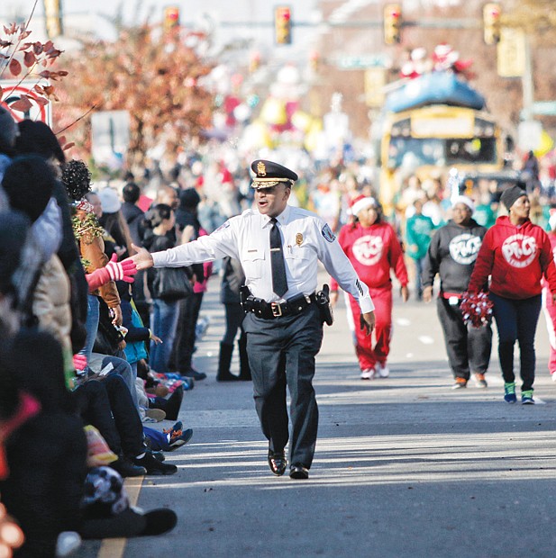 Holiday spirit on parade // Richmond Police Chief Alfred Durham delivers personal and up close greetings to spectators along the parade route. 