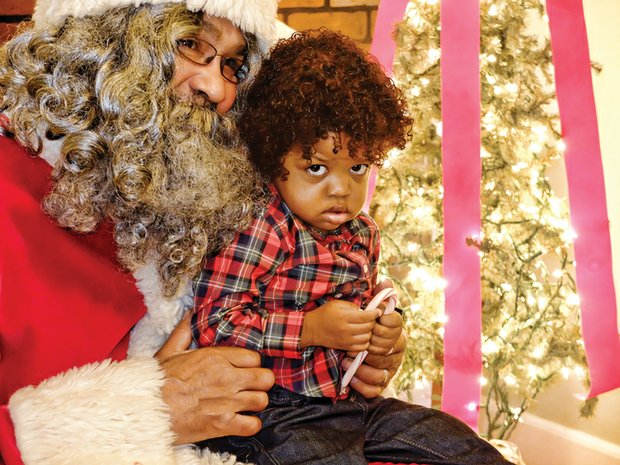 Define ‘naughty or nice’ //
Aiden Hunter, 1, appears none too merry about his encounter with Santa with Soul, the jolly old elf from the North Pole. Santa (Harry Henry) was hearing the wishes of youngsters last Saturday at the Black History Museum and Cultural Center of Virginia’s annual holiday open house in Jackson Ward. Children had their picture taken with Santa, made holiday ornaments and enjoyed holiday music and refreshments with their families and others attending the event. 