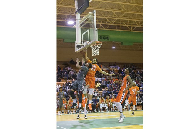 Virginia State University’s Te’Quan Alers goes airborne to block the layup of Virginia Union University player Devin Moore at last Sunday’s game at the Arthur Ashe Athletic Center.