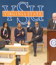 Dr. Makola M. Abdullah waves to the audience as Virginia State University Rector Harry Black introduces him last Friday as the university’s new president. With him, from left, are son Mikaili, daughter Sefiyetu, and his wife, Dr. Ahkinyala Cobb-Abdullah.