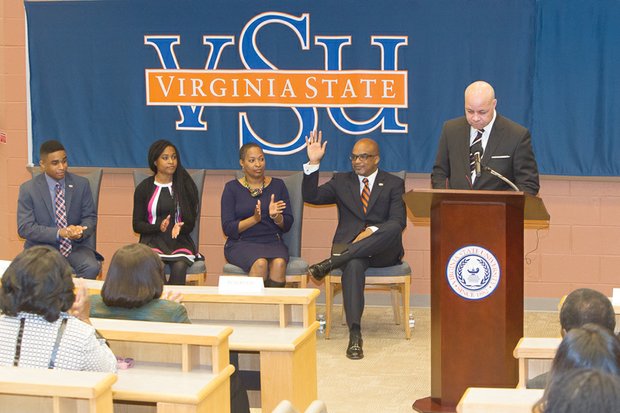 Dr. Makola M. Abdullah waves to the audience as Virginia State University Rector Harry Black introduces him last Friday as the university’s new president. With him, from left, are son Mikaili, daughter Sefiyetu, and his wife, Dr. Ahkinyala Cobb-Abdullah.