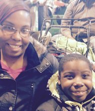 Michelle Daniels and her son, Isaiah, 7, were among the hundreds attending Christmas In the Wards at Olive-Harvey College, 10001 S. Woodlawn Ave. in Chicago. Several needy youngsters, like Isaiah, received free gifts at the event.