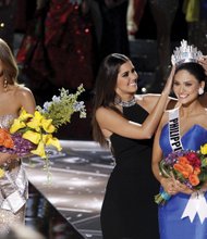 Miss Colombia Ariadna Gutierrez Arevalo, left, stands by as the Miss Universe crown is transferred Sunday to the actual winner of the pageant, Miss Philippines Pia Alonzo Wurtzbach. Host Steve Harvey mistakenly announced the runner up as the winner. He apologized, asking the loudly booing audience not to “hold it against the ladies.” Miss Universe 2014 Paulina Vega placed the crown on the head of the winner.