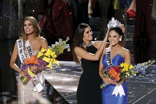 Miss Colombia Ariadna Gutierrez Arevalo, left, stands by as the Miss Universe crown is transferred Sunday to the actual winner of the pageant, Miss Philippines Pia Alonzo Wurtzbach. Host Steve Harvey mistakenly announced the runner up as the winner. He apologized, asking the loudly booing audience not to “hold it against the ladies.” Miss Universe 2014 Paulina Vega placed the crown on the head of the winner.