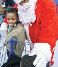 Spreading holiday cheer // Santa Claus suited up to join the Prince Hall Masons of the 26th District to provide holiday cheer and gifts to children from families in need last Saturday at the Walmart on Sheila Lane in South Side. Santa greets Khaliel Walker, left, and Kameron Perez, as they start their shopping trip. 

