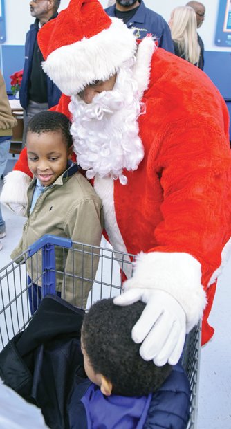 Spreading holiday cheer // Santa Claus suited up to join the Prince Hall Masons of the 26th District to provide holiday cheer and gifts to children from families in need last Saturday at the Walmart on Sheila Lane in South Side. Santa greets Khaliel Walker, left, and Kameron Perez, as they start their shopping trip. 

