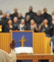 An audience member lifts her hand in praise as she listens to an inspirational song from the Greater Metropolitan Choir on New Year’s Day at the 75th Annual Emancipation Proclamation Day Worship Celebration at Fifth Baptist Church in Richmond’s West End.