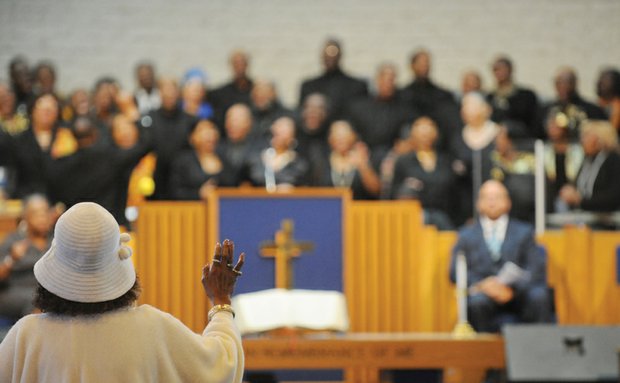 An audience member lifts her hand in praise as she listens to an inspirational song from the Greater Metropolitan Choir on New Year’s Day at the 75th Annual Emancipation Proclamation Day Worship Celebration at Fifth Baptist Church in Richmond’s West End.