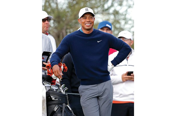 
Tiger Woods waits during a practice round at the Waste Management Phoenix Open golf tournament in January 2015. Because of poor scores, he didn’t qualify to play in the tournament’s final two rounds.