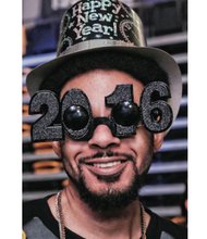 Ringing in the New Year // Charles Johnson, right, turned out in New Year’s gear, including celebratory eyewear, to party with the crowd to live entertainment. Organizers moved the previously free city event from its prior locations at Brown’s Island and Carytown to the Siegel Center and charged a fee