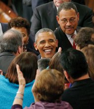 
Members of Congress enthusiastically greet President Obama as he arrives in the House of Representatives to deliver his State of the Union address.