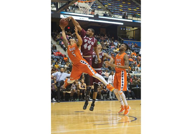 Virginia State University’s Javon Moore, No. 5, is fouled by Virginia Union University’s Devin Moore who attempts to block the shot during Sunday’s Freedom Classic at the Richmond Coliseum. The game was a squeaker, with the VUU Panthers defeating the VSU Trojans 70-68.