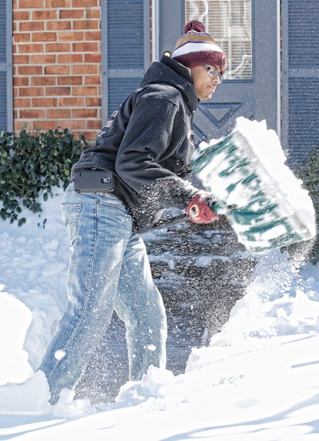 Devin Hayes clears a path from his home Sunday in the 8400 block of Klarey Court in Henrico County. 
