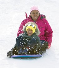 School’s out, sledding’s in //
Jeramia Thomas, 5, closes his eyes to the action as he and Christina Williams, 12, sled down the slopes Monday at Richmond’s Forest Hill Park. With schools and businesses closed, they joined others who took advantage of the Richmond area’s first big snowstorm of the season to go sledding, build snowmen and have snowball fights. The National Weather Service estimated that between 11 and 16 inches of snow fell in Metro Richmond.