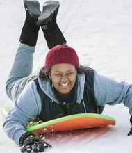 Winter fun, work //  Among those enjoying the city slopes is 13-year-old Nakiya Thomas, left. The snow was not all fun and games for everyone. Many braved the wintry winds and snow to dig out cars and help others. 