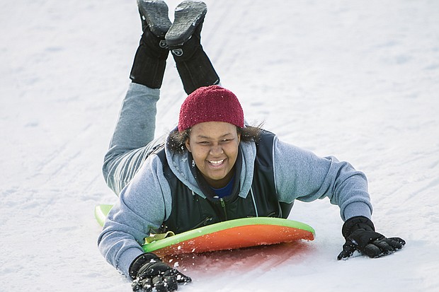 Winter fun, work //  Among those enjoying the city slopes is 13-year-old Nakiya Thomas, left. The snow was not all fun and games for everyone. Many braved the wintry winds and snow to dig out cars and help others. 