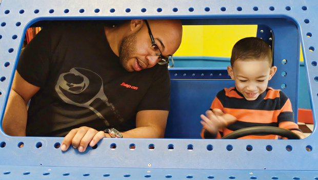 In the driver’s seat Mason Whitaker, 2, gives his father, Richard Whitaker, a driving lesson as they played in a toy car Wednesday at the Children’s Museum of Richmond. enjoying the day with dad, Mason enjoyed activities
that both expand
the imagination and learning.