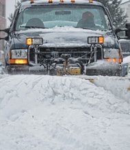 A worker clears a parking lot during the snowstorm that hit the Richmond region three weeks ago.