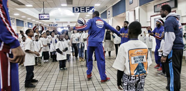 The ‘Thunder Low’ show // Harlem Globetrotters player Thunder Low, center, mesmerizes Richmond’s Carver Elementary School students with his basketball skills. He and other members of the world-renowned basketball team demonstrated their signature dribbling, passing and fancy footwork for youngsters last Thursday at the Greyhound Bus Station on North Boulevard. The team also offered an anti-bullying and teamwork message to the high- achieving students from Carver, which recently was named a Highly Distinguished School by the Virginia Department of Education. The Globetrotters stopped in Richmond on their 90th Anniversary World Tour to perform at the Richmond Coliseum.