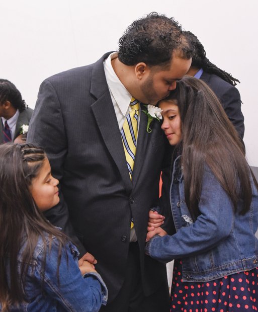 A loving embrace //
Daniel Rodriguez holds his daughters Jasmine, left, and Nicole, close on Sunday afternoon at the fifth annual “Dance of their Own” at the Richmond Justice Center in Shockoe Bottom. The semiformal event provided
the opportunity for selected male inmates to share the afternoon with their daughters and enjoy comedy, dance, games and other activities. The event was part of the Date with Dad Weekend sponsored by the nonprofit Girls for
a Change. Richmond native Chad L. Coleman of AMC’s “The Walking Dead” and Malik Yoba of the hit TV series “Empire” were special guests at the dance.