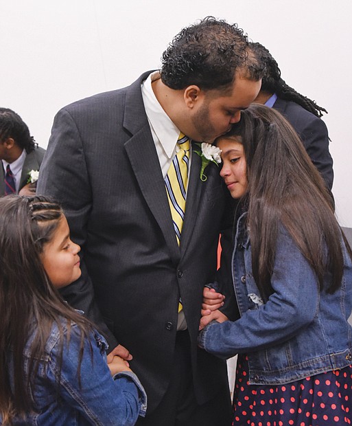 A loving embrace //
Daniel Rodriguez holds his daughters Jasmine, left, and Nicole, close on Sunday afternoon at the fifth annual “Dance of their Own” at the Richmond Justice Center in Shockoe Bottom. The semiformal event provided
the opportunity for selected male inmates to share the afternoon with their daughters and enjoy comedy, dance, games and other activities. The event was part of the Date with Dad Weekend sponsored by the nonprofit Girls for
a Change. Richmond native Chad L. Coleman of AMC’s “The Walking Dead” and Malik Yoba of the hit TV series “Empire” were special guests at the dance.