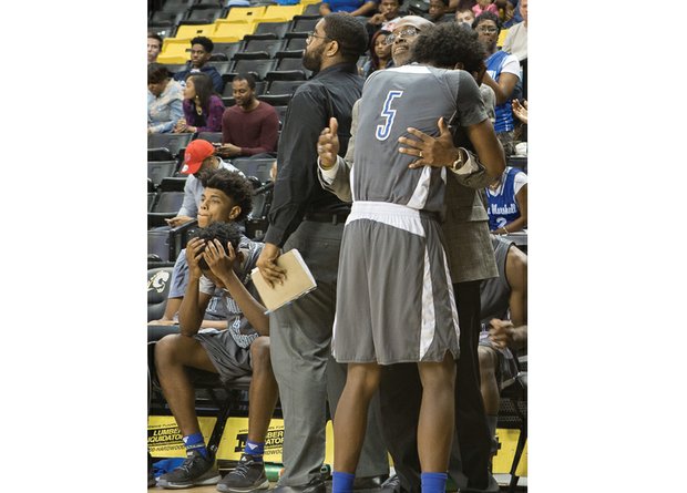 John Marshall High’s Xavier Trent seeks consolation from Assistant Coach Kevin Bettis in the late stages of the Justices’ 75-62 loss to Portsmouth’s I.C. Norcom High School in the State 3A semifinals last Friday at the Siegel Center at Virginia Commonwealth University.