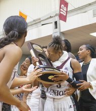 Virginia Union University’s Kiana Johnson kisses the NCAA regional championship trophy she and her teammates were awarded after Monday night’s victory over West Liberty University at Barco-Stevens Hall.