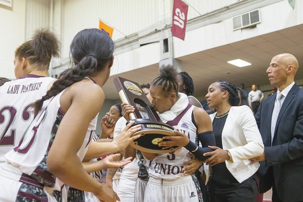 Virginia Union University’s Kiana Johnson kisses the NCAA regional championship trophy she and her teammates were awarded after Monday night’s victory over West Liberty University at Barco-Stevens Hall.