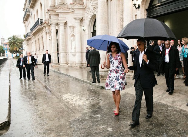 President Obama and First Lady Michelle Obama hold hands Sunday as they walk through the rain to the motorcade after touring Old Havana, Cuba. President Obama, who met with Cuban President Raul Castro and other officials, is the first sitting U.S. president in 88 years to visit the island nation after diplomatic relations were restored on July 20, 2015.
