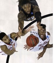 Virginia Commonwealth University’s Mo Alie-Cox, center, tries to reach over University of Oklahoma’s Isaiah Cousins, left, and Buddy Hield for a rebound during Sunday’s NCAA Tournament second round game in Oklahoma City.