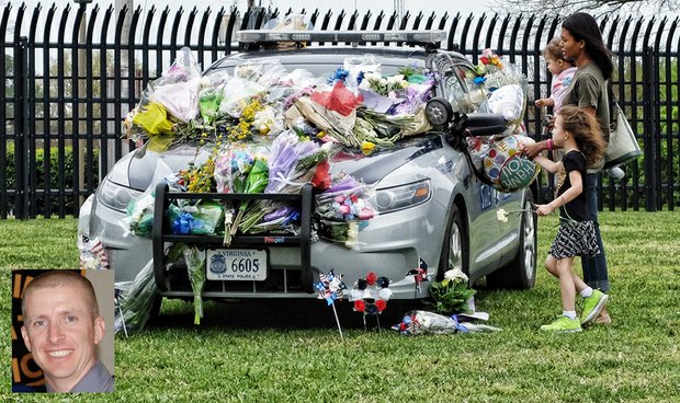 Honoring slain trooper //
Angela Courteau and her daughters, Elara, 5, and Nina, 1, place flowers on the car of slain Virginia State Police Trooper Chad P. Dermyer last Friday at State Police headquarters in Chesterfield County. People from Metro Richmond and around the state and nation paid their respects to the 37-year-old Michigan native who was fatally shot during a counterterrorism training exercise last Thursday at the Richmond Greyhound bus station. Authorities said other troopers inside the bus station then shot and killed the gunman, James Brown III of Aurora, Ill. Two women were wounded, including an athlete from the University of Binghamton in New York who was headed to a track and field event in Williamsburg. They were hospitalized with injuries described as not life threatening. Gov. Terry McAuliffe and police officers from 20 states were among the thousands of mourners at Trooper Dermyer’s funeral Tuesday in Hampton. He was buried in Gloucester County.