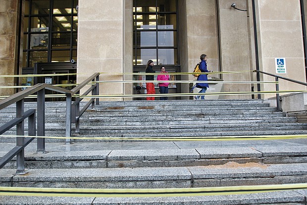 
Yellow tape now blocks the granite steps leading into the Richmond Public Library’s Main Branch in Downtown. Over the years, winter’s cold has cracked the steps, making them dangerous, according to Clay Dishon, interim library director. The city Department of Public Works is planning needed repairs so patrons can once again use the stairway at 101 E. Franklin St.