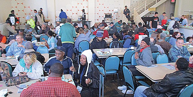 Community members enjoy food and conversation last Friday at Centenary United Methodist Church’s lunch program at the former Aurora nightclub at 4th and Grace streets in Downtown. Below, Dr. Matt Bates, right, pastor of Centenary United Methodist Church, and Al Richardson, the church’s facilities manager, help spearhead the longtime weekly feeding program.