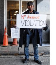 W.B. Braxton Bantu, aka “Scout Leader Bat,” one of the rally organizers, stands at the entrance to the emergency overflow shelter last Friday night.