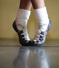 Morgan Bullock poses in front of a mirror during a recent practice. She shows off the special shoes she uses to perform the fast-paced Irish dance routines.