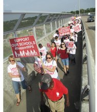 
Marchers cross the Martin Luther King Jr. Memorial Bridge on Monday en route to a rally outside Richmond City Hall seeking more money for Richmond Public Schools.
