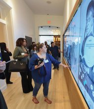 Visitors get a first look and touch of the new interactive displays installed at the Black History Museum Cultural Center of Virginia during a media tour last week. The screens are positioned throughout the museum, which also features a 55-inch touch table.  