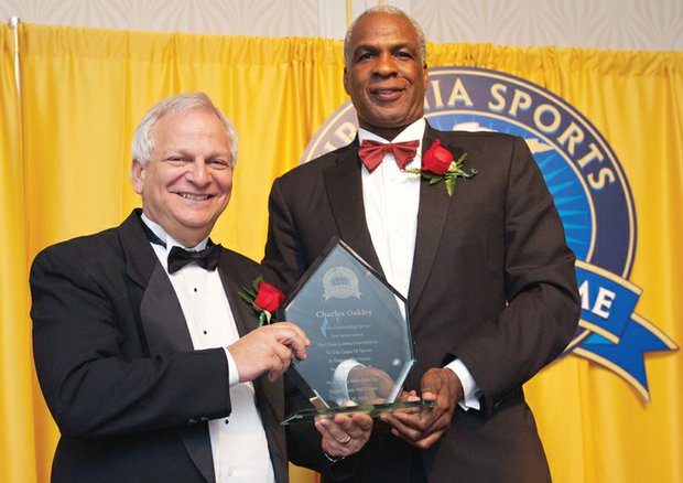 Retired NBA star Charles Oakley is presented with an award last Saturday during his induction into the Virginia Sports Hall of Fame in Portsmouth by Joel Rubin, chairman of the Hall of Fame board.