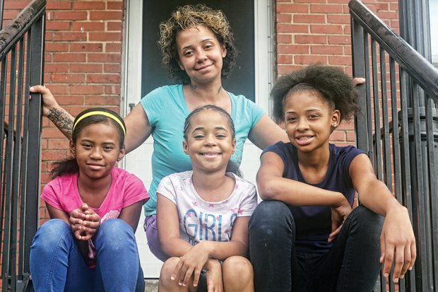 
Tara Spencer sits on the porch of her apartment on Creighton Road with her daughters, from left, Dionicia, 8, La-Taja, 6, and Japria, 12.

