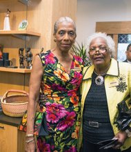 Dr. and Mrs. D. Omar Watson engage in an exhibit in the shadow of the cast of a statue of Richmond native and tennis great Arthur Ashe Jr. that now sits on Monument Avenue. 
