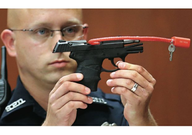 Sanford, Fla., police officer Timothy Smith holds up the 9mm handgun used to kill Trayvon Martin during the 2013 murder trial of George Zimmerman. Mr. Zimmerman was acquitted of second-degree murder in the slaying of the unarmed 17-year-old.