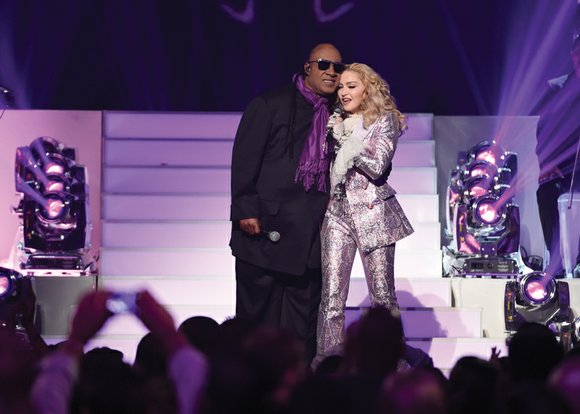 Madonna paid homage to Prince by wearing his signature color and bringing another icon, Stevie Wonder, onstage to sing the ...