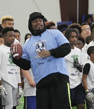 Marshawn Lynch, who retired earlier this year from the Seahawks, prepares to throw a pass to campers.
Below, Maurice Canady, a standout at Varina High School and the University of Virginia who was drafted just weeks ago in the sixth round by the Baltimore Ravens, takes a moment to encourage camp participant Debin Raines.