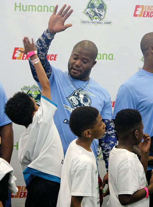 The future of the game // Former Seattle Seahawks fullback and Richmond native Michael Robinson returned home last weekend to host his annual football camp for football enthusiasts ages 8 to 16.
Scores of youngsters turned out for the event at Sports Reality Performance in Mechanicsville to learn tips from the pro himself, left, and several of his notable NFL friends who also worked with the youngsters.