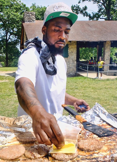 Jerome Ruffin prepares burgers last Saturday for his family’s annual Memorial Weekend cookout in Byrd Park. Above, Larry Smith shows off his catch at Chapel Island Park in the East End. 