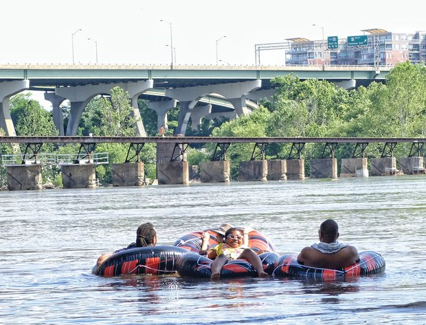 Lynnara Brice, 7, relaxes on the James River last Saturday with her family, from left, Rich Green, Sandra Gebhardt and Alexander Brice.