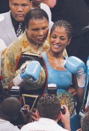 Mr. Ali proudly stands with daughter, boxing champion Laila Ali, after she won the Super Middleweight title in June 2005 at a match in Washington. 